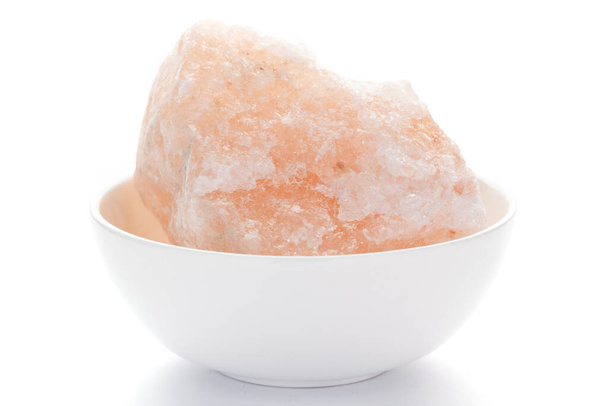 Close-up of coarse Himalayan Pink Salt (sodium chloride) edible on white ceramic bowl. - Photo, Image