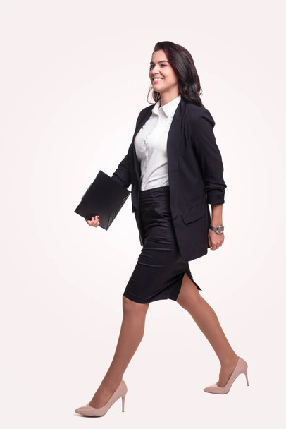 Confident businesswoman in suit with clipboard - Foto, afbeelding