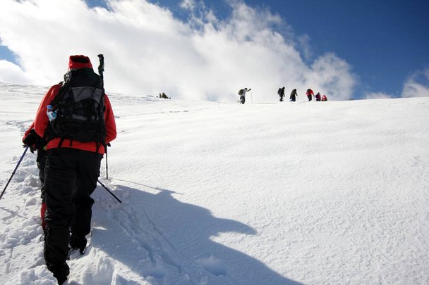 Groupe d'alpinistes marchant à travers les montagnes couvertes de neige - Photo, image