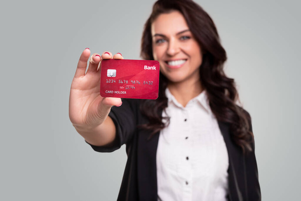 クレジットカードを示すフレンドリーな女性 - 写真・画像