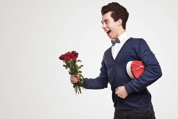 Cheerful gentleman with flowers and gift box - Photo, image