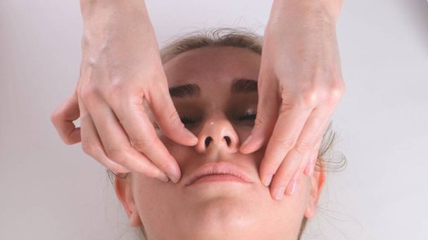 Beautiful woman in salon having facial massage. - Photo, Image