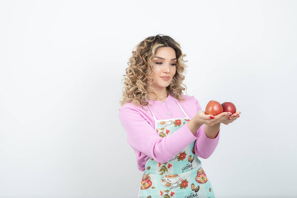 Beautiful curly blonde housewife with red apples standing. High quality photo - Valokuva, kuva