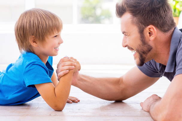 Father and son competing in arm wrestling - Photo, image