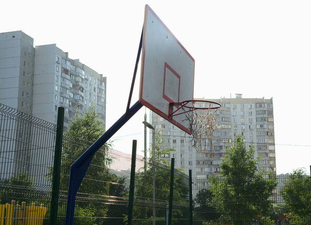 A basketball hoop on the street against the background of a very bright morning sun. - Foto, afbeelding