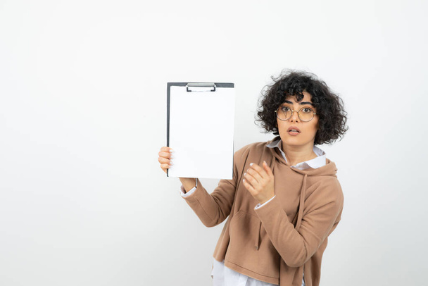 Portrait de jeune femme dans des lunettes tenant le presse-papiers vide. Photo de haute qualité - Photo, image