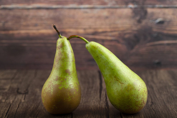 Two ripe delicious green pears on wooden background. High quality photo - Фото, зображення