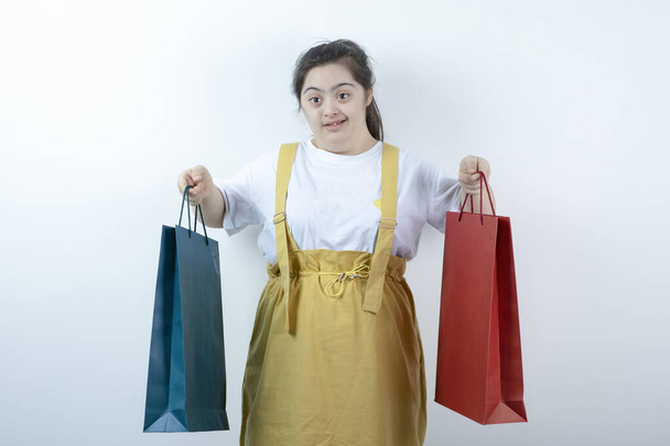 Alışveriş torbası tutan Down sendromlu genç bir kızın portresi. Yüksek kalite fotoğraf - Fotoğraf, Görsel