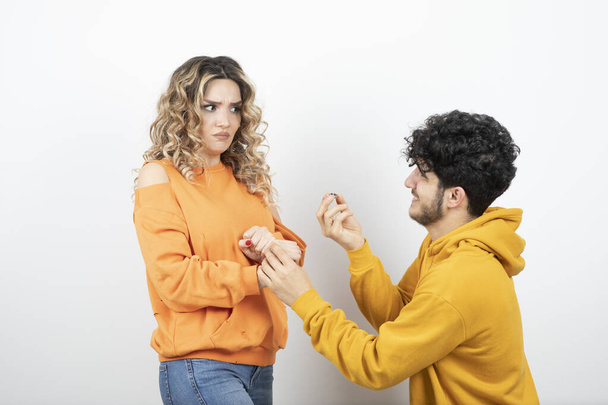 Brunette guy doing proposal to a young wavy-haired woman . High quality photo - Photo, Image