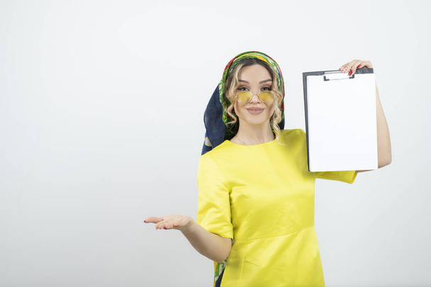 Photo of cute woman in headkerchief holding clipboard . High quality photo - Photo, Image