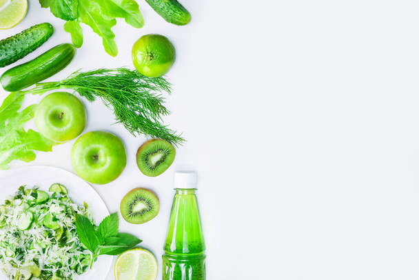 Fresh green vegetables, fruits and green smoothie in bottle. Top view with copy space. Detox, diet or healthy food concept - Photo, Image