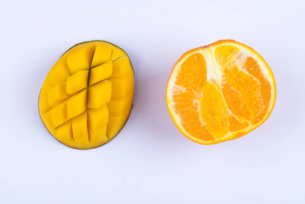 Süße Orangenscheiben mit Mangofruchtscheiben auf weißem Hintergrund. Hochwertiges Foto - Foto, Bild
