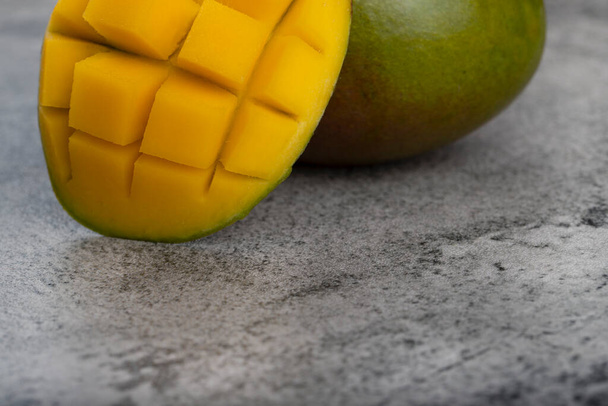 Frutto fresco di mango con fette poste su fondo pietra. Foto di alta qualità - Foto, immagini