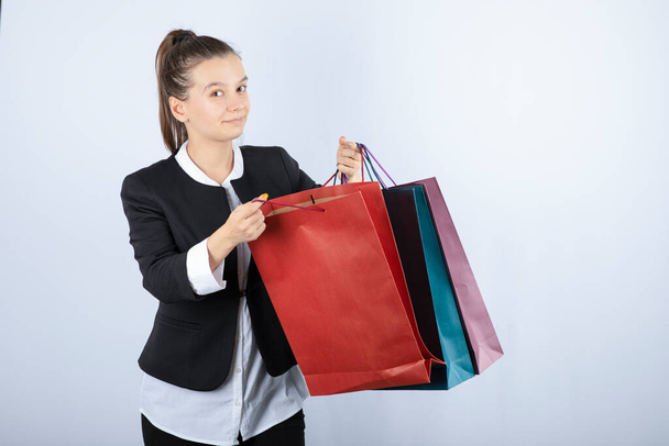 Portrait of beautiful woman with shopping standing and posing on white background. High quality photo - Foto, afbeelding