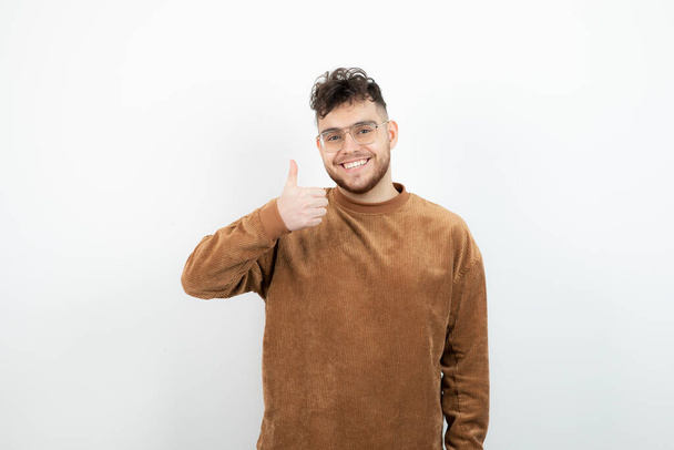 Photo of young handsome man standing and giving thumbs up. High quality photo - Photo, Image