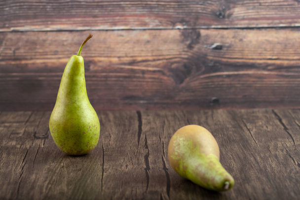 Two ripe delicious green pears on wooden background. High quality photo - Zdjęcie, obraz