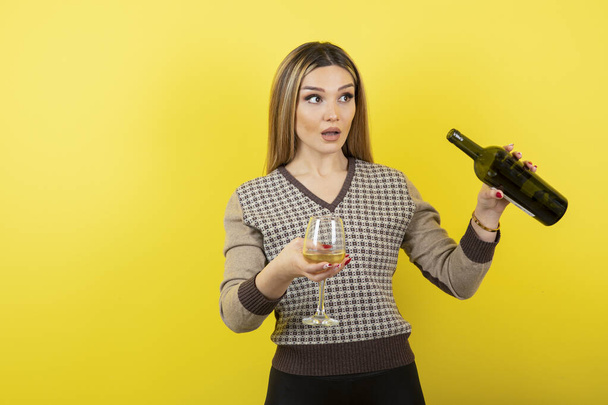 Portrait of young beautiful woman with glass of white wine posing. High quality photo - Foto, afbeelding