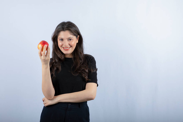 Fénykép gyönyörű fiatal nő fekete felső kezében friss alma. Kiváló minőségű fénykép - Fotó, kép