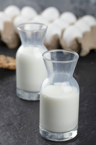 Zavřít fotografii dvou lahví mléka ve fontu hromádky vajec. Kvalitní fotografie - Fotografie, Obrázek