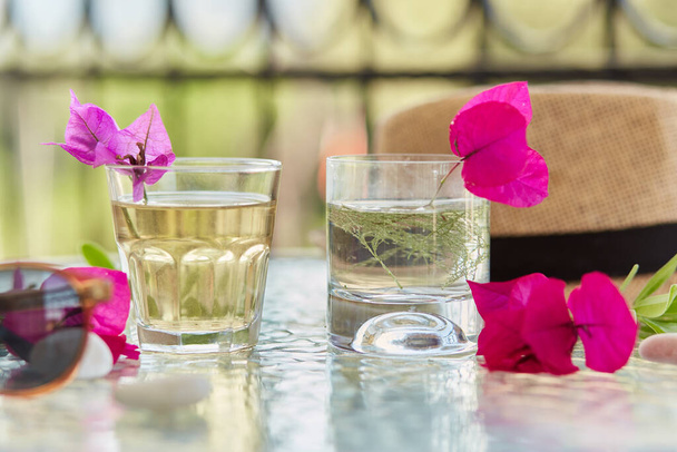 Heldere zomer zelfgemaakte cocktails close-up en roze bloemen van bougainvillea decoraties met sunglasess en zomerhoed. Zomer wallpaper. - Foto, afbeelding