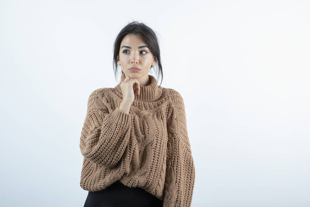 Photo of beautiful woman in knitted sweater standing on white background. High quality photo - Photo, image
