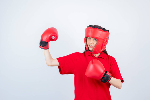 Image of young teen girl in red uniform wearing boxing glove . High quality photo - Foto, afbeelding