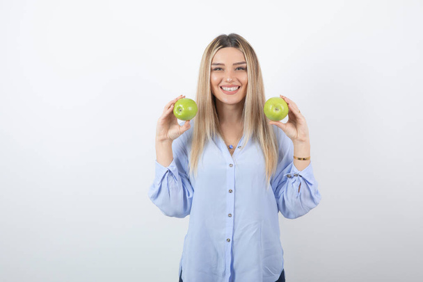 Portrait photo of a pretty attractive woman model standing and holding fresh apples . High quality photo - Photo, image
