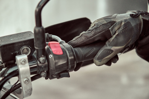 Biker holds onto throttle handle of a motorcycle. Close up shot - Φωτογραφία, εικόνα