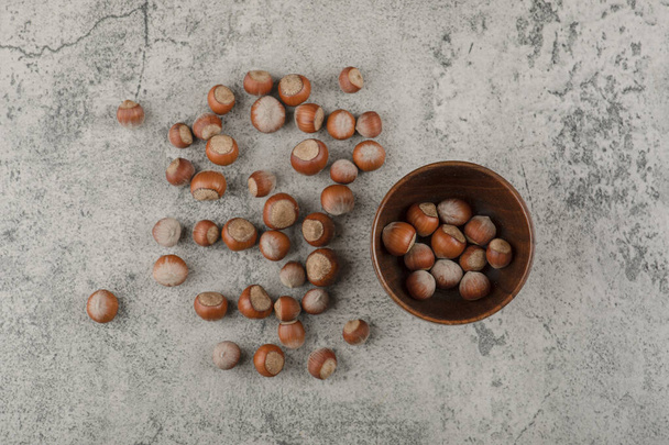 Healthy macadamia nuts in shell on a stone background. High quality photo - Фото, изображение