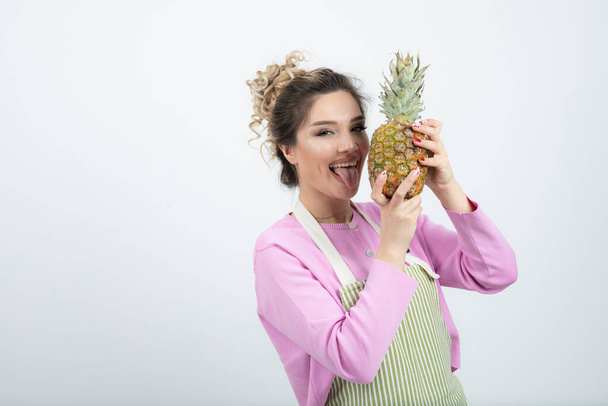 Kaunis nainen esiliina tilalla kypsä trooppinen ananas. Laadukas kuva - Valokuva, kuva