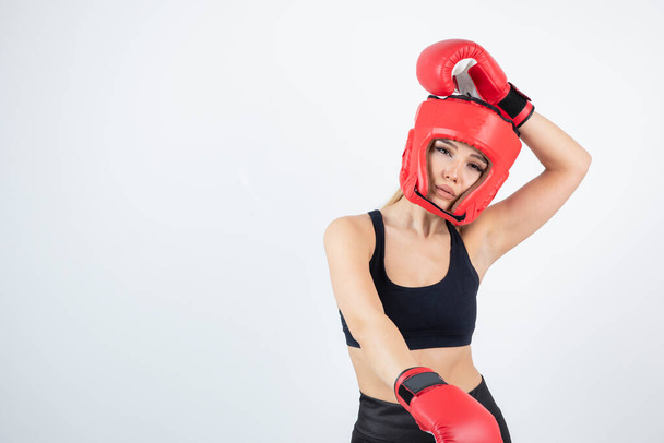 赤い手袋とヘルメットの訓練で若い女性ボクサーの肖像画。高品質の写真 - 写真・画像