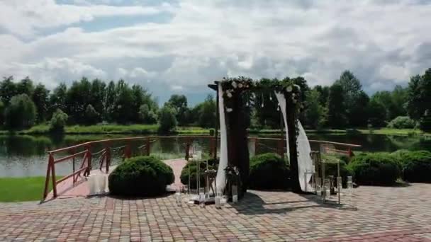 Krásný svatební oltář na břehu rybníka. Romantické místo mezi krásnou přírodou. Služba dekorace a svatebních organizací. Zobrazení dronů, pan - Záběry, video