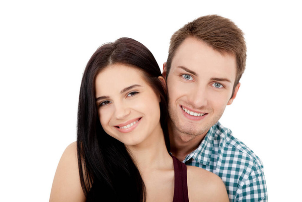 Happy young couple with white perfect smile in summer clothing embracing and looking camera on white background - Foto, immagini