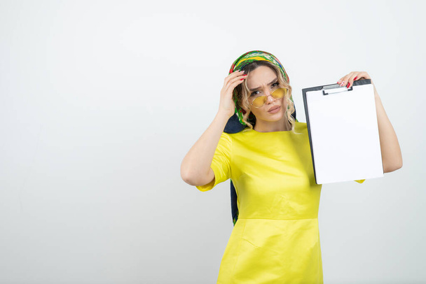 Photo of cute woman in headkerchief holding clipboard . High quality photo - Photo, Image