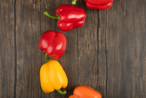 Čerstvé sladké papriky umístěné na dřevěném pozadí. Kvalitní fotografie - Fotografie, Obrázek