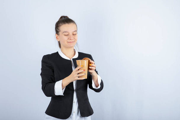 Portrait of beautiful woman with cup of coffee standing on white background. High quality photo - Фото, изображение