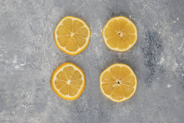 Cuatro rodajas de limón agrio sobre un fondo de mármol. Foto de alta calidad - Foto, Imagen