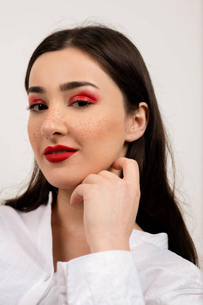 Close up photo of pretty woman posing with beautiful make-up against white wall . High quality photo - Zdjęcie, obraz