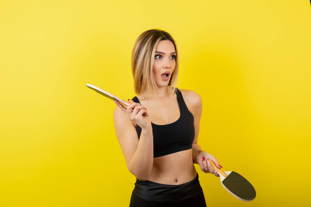 Portrait de jeune femme debout et tenant des raquettes de tennis de table. Photo de haute qualité - Photo, image