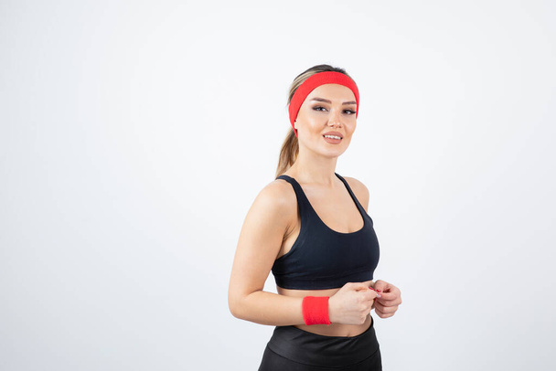 Kırmızı saç bandı takan genç atletik kadın portresi. Yüksek kalite fotoğraf - Fotoğraf, Görsel