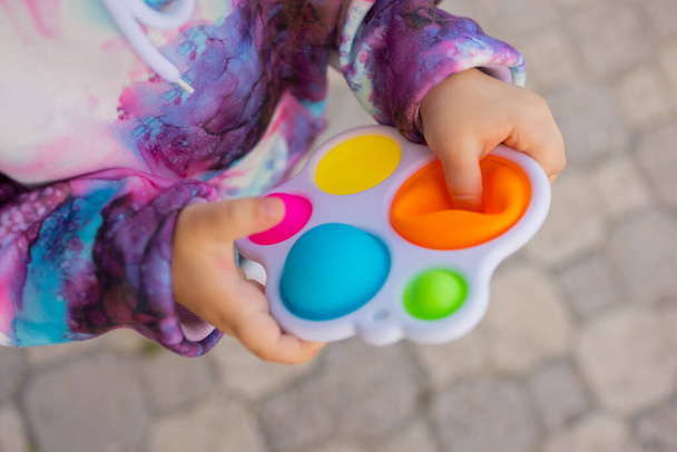 Pop it fidget toy in girl hands. Colorful antistress kids toy fidget. - Fotoğraf, Görsel