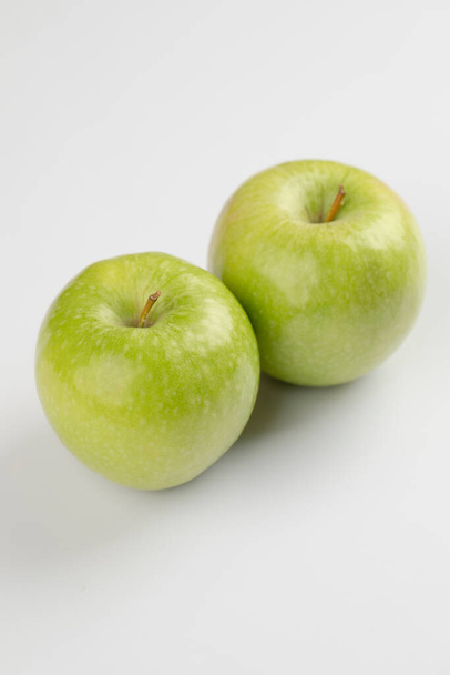 Twee rijpe groene appels geplaatst op witte achtergrond. Hoge kwaliteit foto - Foto, afbeelding
