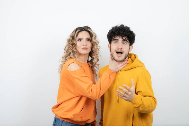 Young curly haired woman choking brunette man. High quality photo - Foto, Bild
