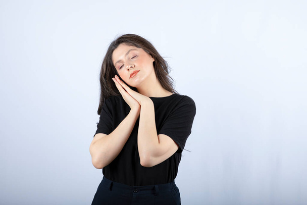 Portrait of young woman in black outfit sleeping while standing. High quality photo - Foto, Imagem