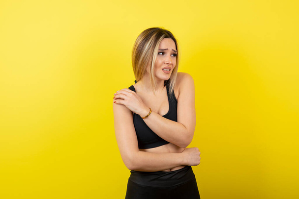 Muotokuva nuoresta naisesta seisomassa ja poseeraamassa keltaisen muurin päällä. Laadukas kuva - Valokuva, kuva