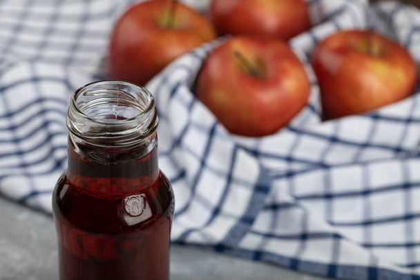 縞模様のテーブルクロスに赤いジュースのおいしい赤いリンゴとガラス。高品質の写真 - 写真・画像