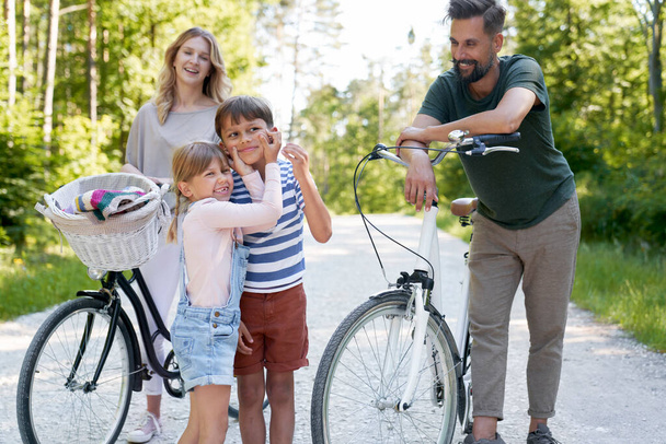 Famiglia con bambini giocherelloni mentre giro in bicicletta nel bosco                                - Foto, immagini