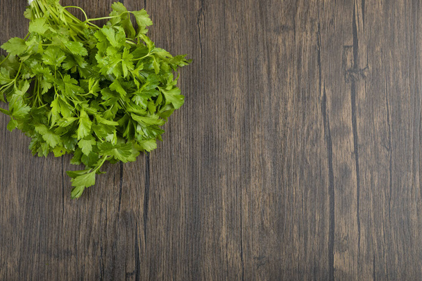 Folhas de salsa verdes saudáveis colocadas no fundo de madeira. Foto de alta qualidade - Foto, Imagem