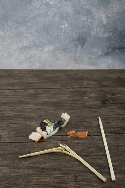 Classic Philadelphia sushi rolls with chopsticks on wooden surface. High quality photo - 写真・画像