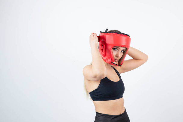 Mujer rubia joven en la parte superior de la cosecha con casco de boxeo rojo. Foto de alta calidad - Foto, imagen